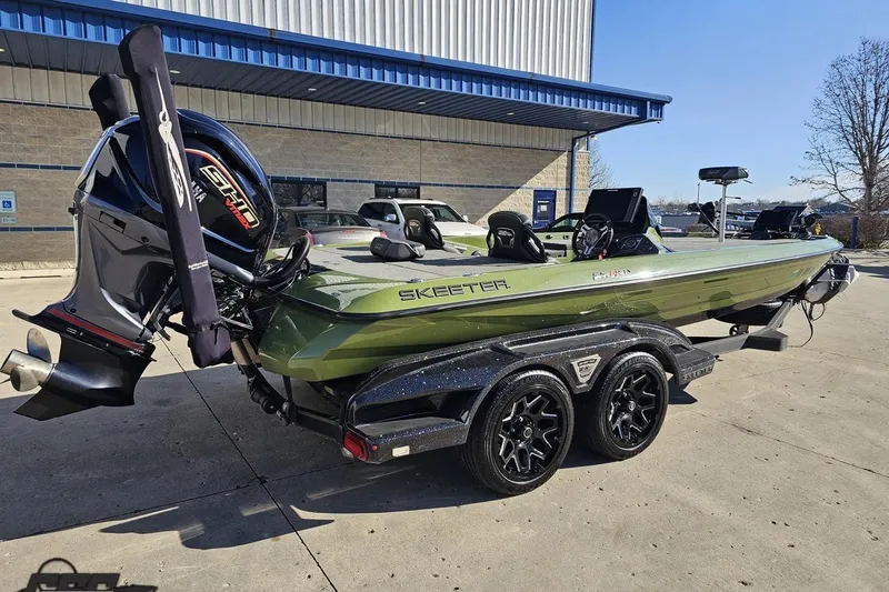 Slide: The Image of 2022 Skeeter FXR21 Apex boat on trailer, green exterior, parked outdoors. - 11