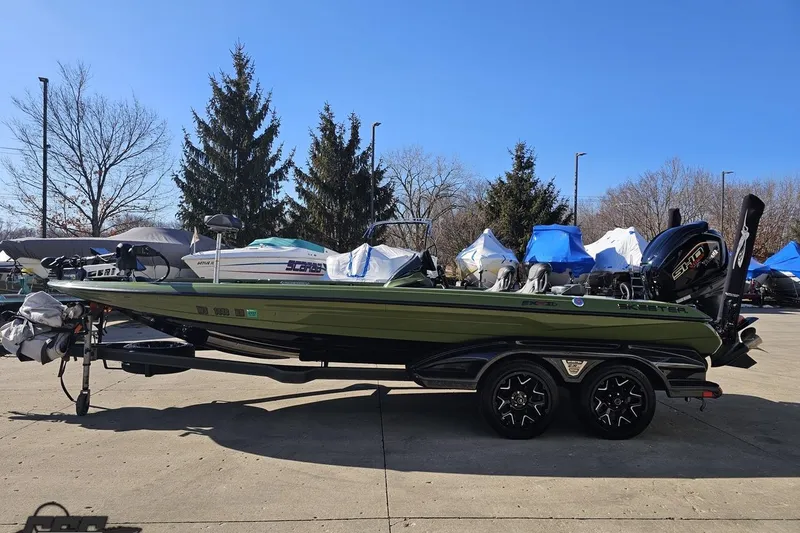 Slide: The Image of 2022 Skeeter FXR21 Apex boat on trailer, parked outdoors with trees in background. - 26