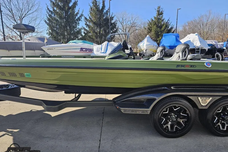 Slide: The Image of 2022 Skeeter FXR21 Apex boat in green, parked on a trailer, surrounded by covered boats. - 27