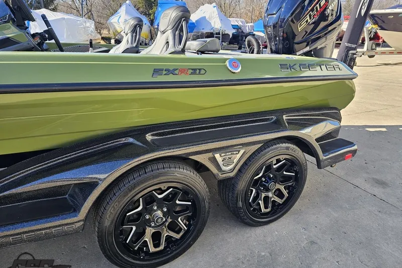 Slide: The Image of 2022 Skeeter FXR21 Apex boat with dual black wheels and green hull. - 28