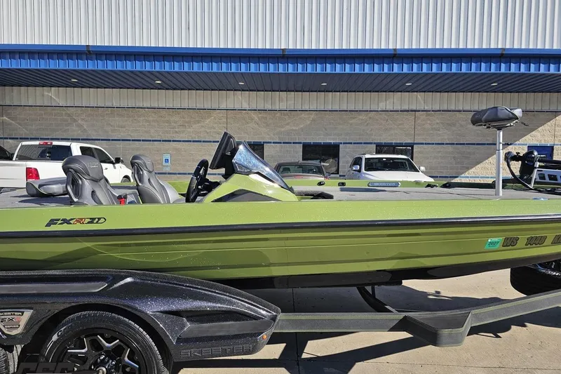 Slide: The Image of 2022 Skeeter FXR21 Apex boat in green, parked outside a building. - 4