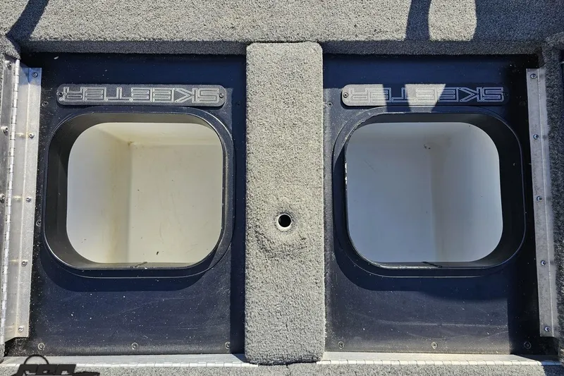 Slide: The Image of 2022 Skeeter FXR21 Apex boat storage compartments, carpeted deck, open hatches. - 55