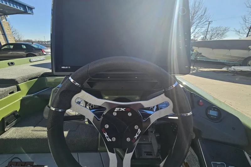 Slide: The Image of 2022 Skeeter FXR21 Apex boat cockpit with steering wheel and Helix 15 display. - 62