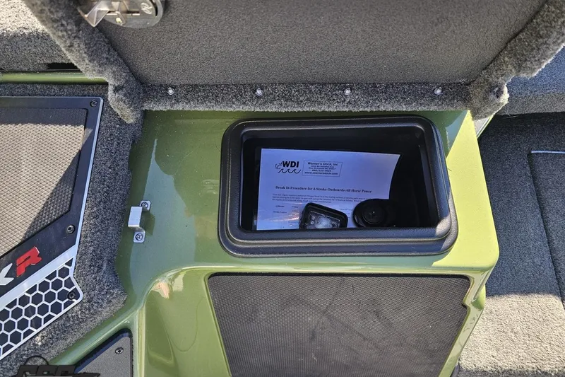 Slide: The Image of 2022 Skeeter FXR21 Apex storage compartment with documents and equipment inside. - 69