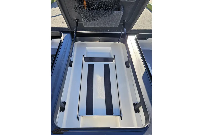 Slide: The Image of 2022 Skeeter FXR21 Apex boat storage compartment with open lid and netting. - 73