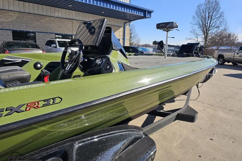Slide: The Image of 2022 Skeeter FXR21 Apex boat in green, parked outdoors near a building. - 8