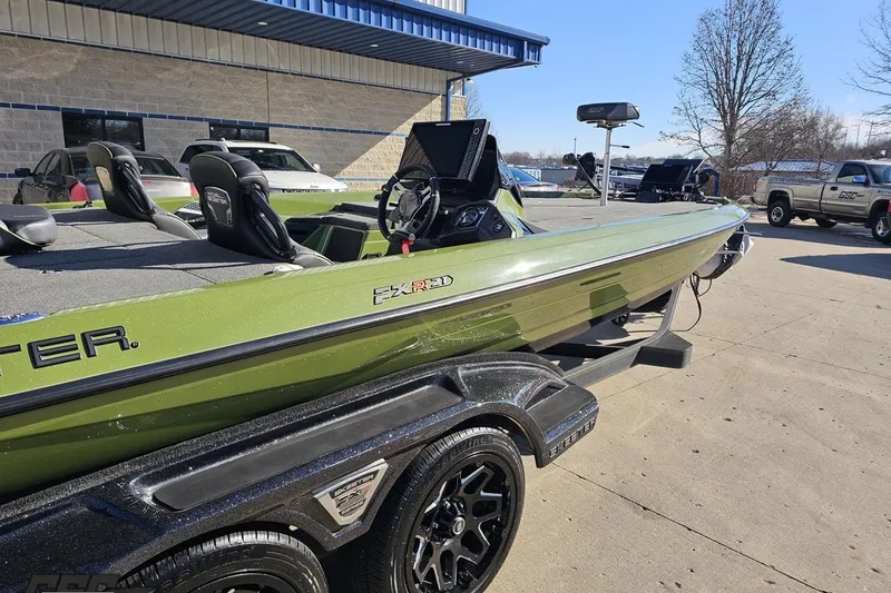 Slide: The Image of 2022 Skeeter FXR21 Apex boat in green on trailer, parked outdoors. - 9