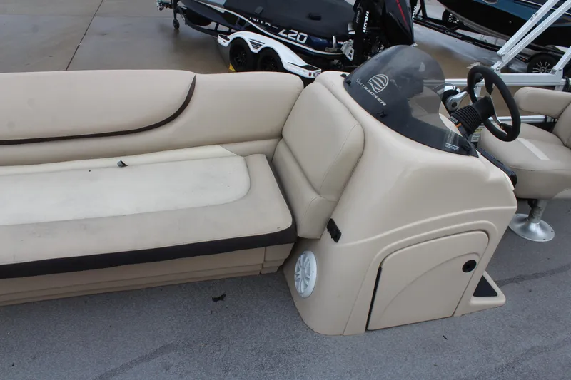 Slide: The Image of 2016 Sun Tracker Party Barge 24 XP3 interior with beige seating and steering console. - 16