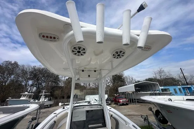 Slide: The Image of 2018 Tidewater 230 CC Adventure boat with T-top and rod holders, docked outdoors. - 10