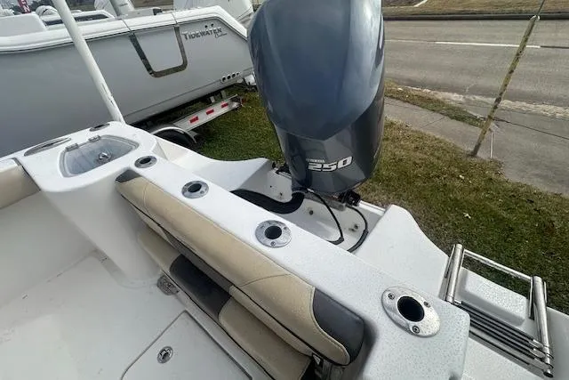 Slide: The Image of 2018 Tidewater 230 CC Adventure boat with powerful 250 engine, featuring rod holders and seating. - 14