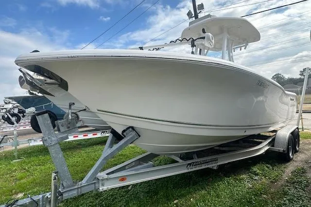 The Image of 2018 Tidewater 230 CC Adventure boat on trailer, parked on grass under cloudy sky. - 6