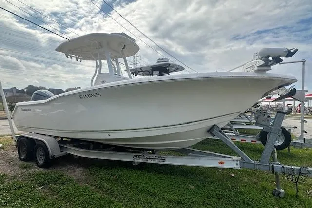 Slide: The Image of 2018 Tidewater 230 CC Adventure boat on trailer, parked outdoors under cloudy sky. - 7