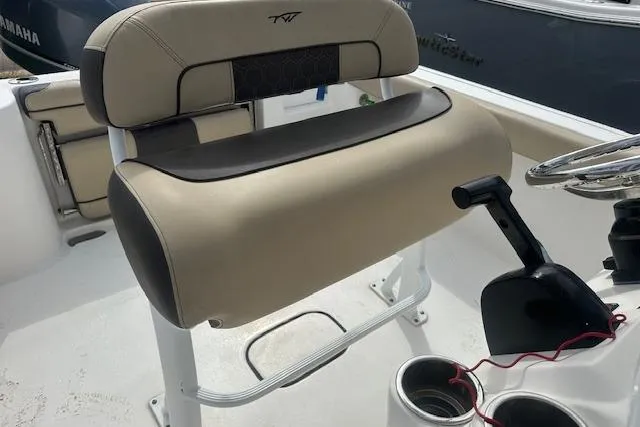 Slide: The Image of 2018 Tidewater 230 CC Adventure boat seat and console, featuring beige and black upholstery. - 18