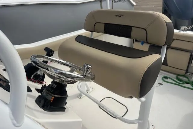 Slide: The Image of 2018 Tidewater 230 CC Adventure boat helm with cushioned seat and steering wheel. - 19