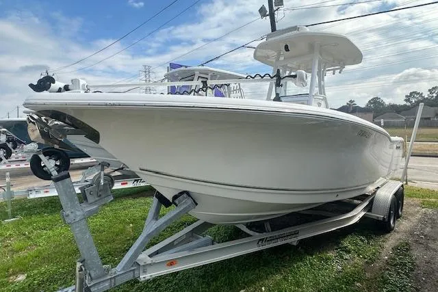 Slide: The Image of 2018 Tidewater 230 CC Adventure boat on trailer, parked outdoors under cloudy sky. - 20