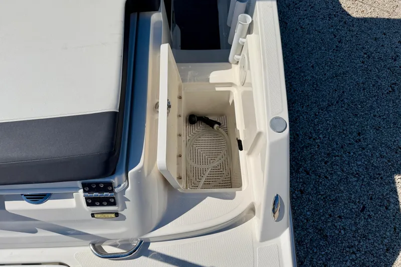 Slide: The Image of 2020 Bayliner VR5 Bowrider OB boat storage compartment with hose and seating area. - 28