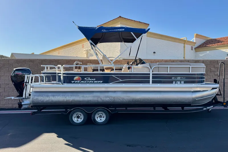 The Image of 2019 Sun Tracker SportFish 22 DLX pontoon boat with canopy on trailer. - 0