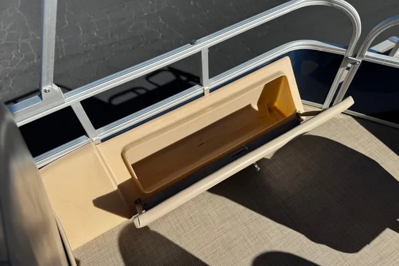 Slide: The Image of 2019 Sun Tracker SportFish 22 DLX boat storage compartment with beige interior and railing. - 19