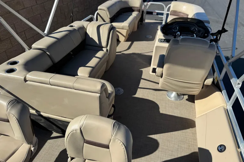 Slide: The Image of 2019 Sun Tracker SportFish 22 DLX interior with beige seating and steering console. - 24