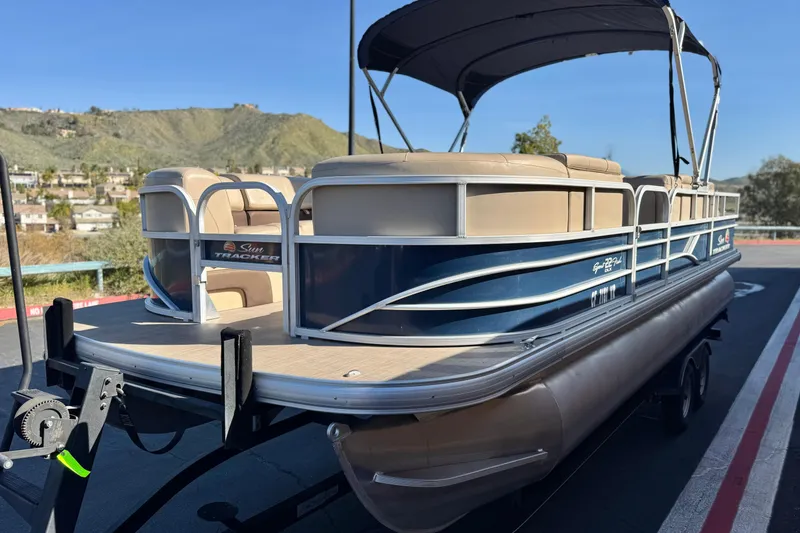Slide: The Image of 2019 Sun Tracker SportFish 22 DLX pontoon boat on trailer, scenic background. - 3