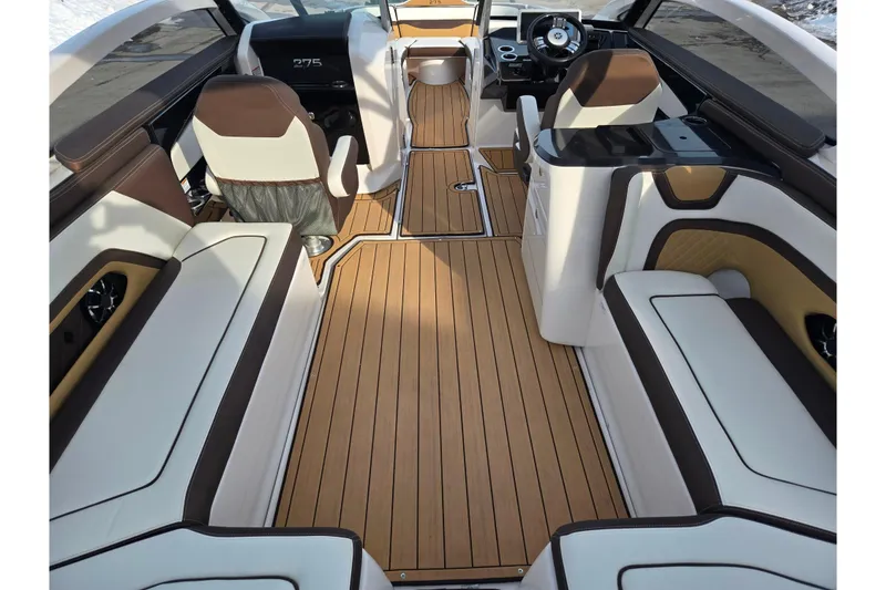 Slide: The Image of 2022 Yamaha Boats 275SD interior with luxurious seating and wood-style flooring. - 12