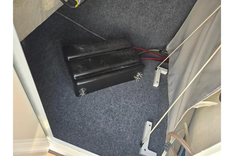 Slide: The Image of 2022 Yamaha Boats 275SD interior storage compartment with battery and wiring. - 18