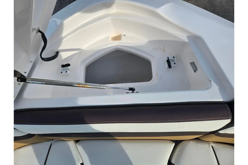Slide: The Image of Open storage compartment in 2022 Yamaha Boats 275SD, featuring cushioned seating and hydraulic support. - 21