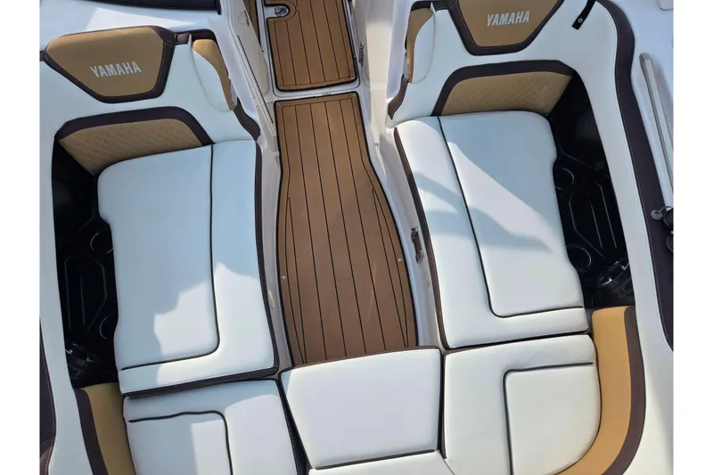 Slide: The Image of 2022 Yamaha Boats 275SD interior with white and tan seating, teak-style flooring. - 22
