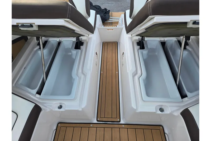 Slide: The Image of 2022 Yamaha Boats 275SD interior with open storage compartments and teak-style flooring. - 26