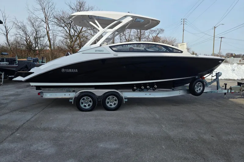 Slide: The Image of 2022 Yamaha Boats 275SD on trailer, sleek black and white design, parked outdoors. - 4