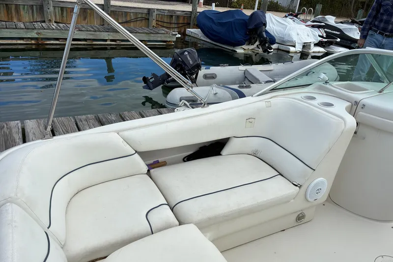 Slide: The Image of 1999 Sea Ray 210 Sundeck boat interior with white seating at dock. - 5