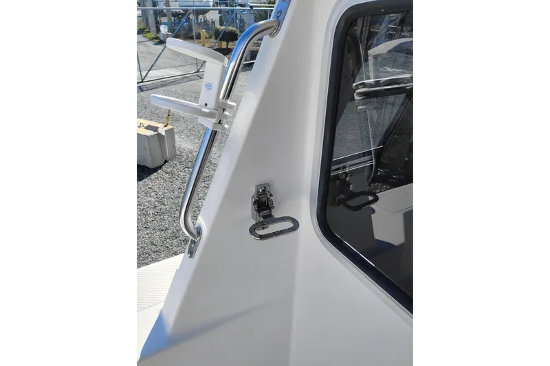 Slide: The Image of 1997 SeaSport Explorer 2400 boat exterior with stainless steel handrail and window detail. - 13