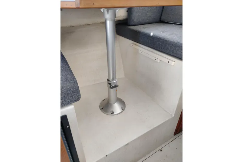 Slide: The Image of Interior seating area of a 1997 SeaSport Explorer 2400 boat with metal table support. - 19