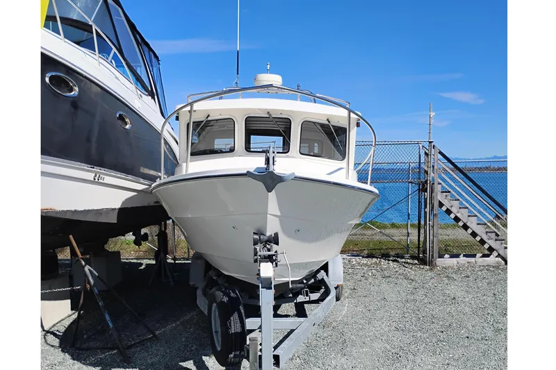 Slide: The Image of 1997 SeaSport Explorer 2400 boat on trailer by the water. - 2