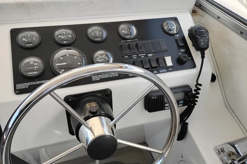 Slide: The Image of 1997 SeaSport Explorer 2400 dashboard with steering wheel, gauges, and radio controls. - 29