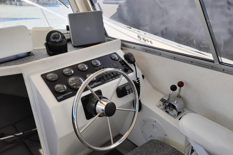 Slide: The Image of 1997 SeaSport Explorer 2400 helm with steering wheel, gauges, and controls. - 30