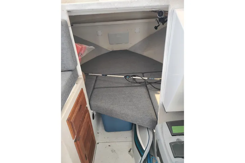 Slide: The Image of 1997 SeaSport Explorer 2400 cabin interior with gray cushions and fishing rod. - 31