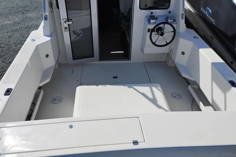 Slide: The Image of 1997 SeaSport Explorer 2400 boat cockpit with steering wheel and seating area. - 14