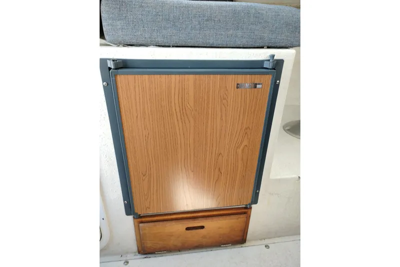 Slide: The Image of 1997 SeaSport Explorer 2400 interior with wooden cabinet and cushioned seating. - 16