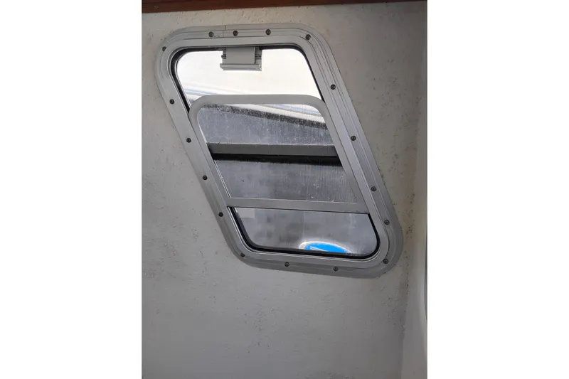 Slide: The Image of 1997 SeaSport Explorer 2400 cabin window with metal frame and sliding glass. - 23