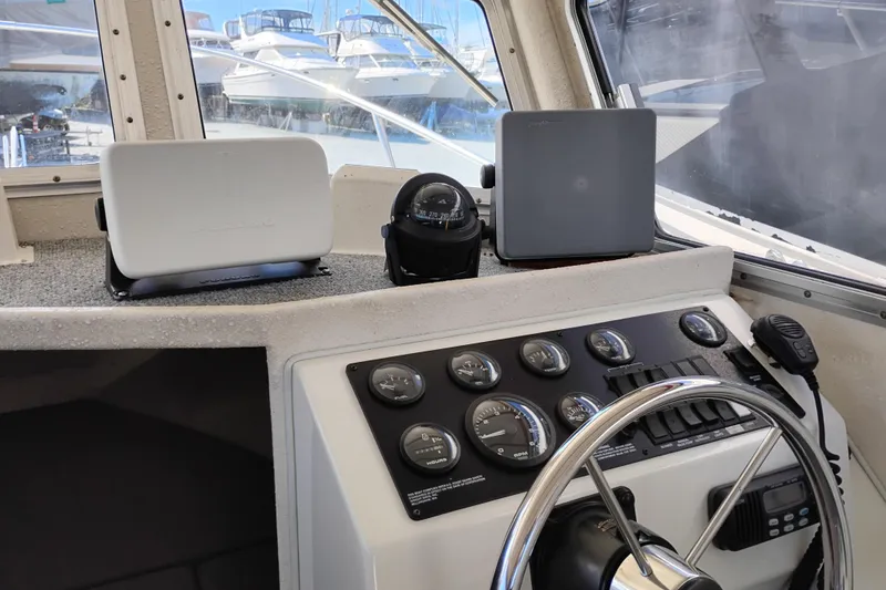 Slide: The Image of 1997 SeaSport Explorer 2400 helm with gauges, compass, and marine electronics. - 28