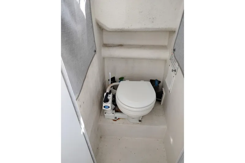 Slide: The Image of 1997 SeaSport Explorer 2400 boat bathroom with compact marine toilet. - 34