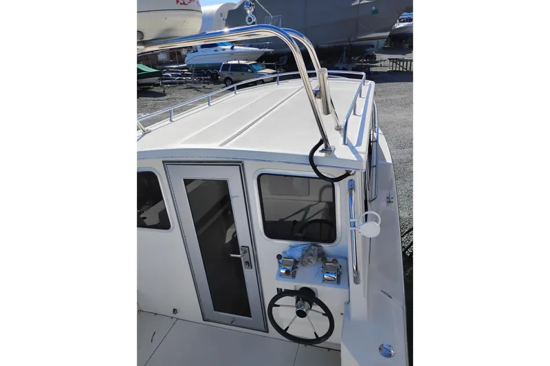 Slide: The Image of 1997 SeaSport Explorer 2400 boat with helm and cabin view, docked outdoors. - 5