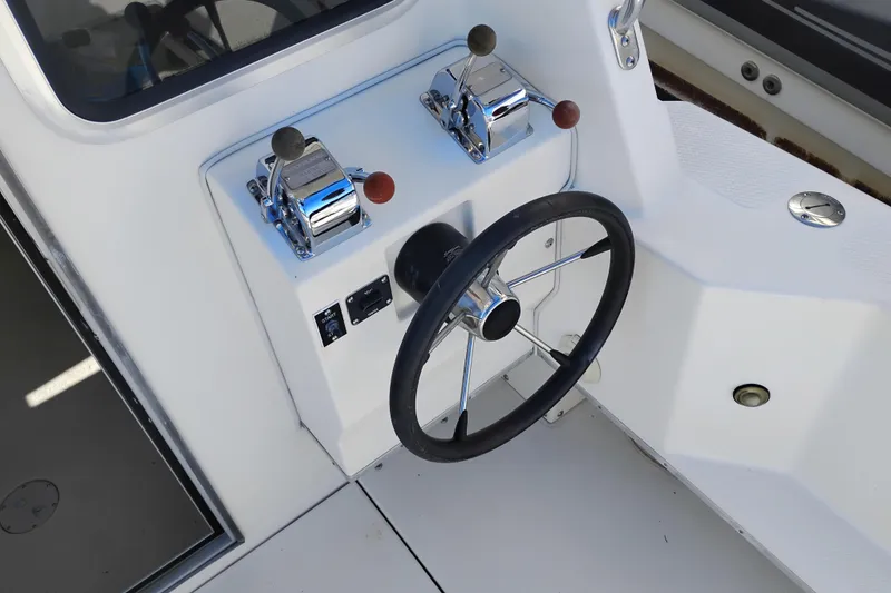 Slide: The Image of Steering wheel and controls of a 1997 SeaSport Explorer 2400 boat. - 6