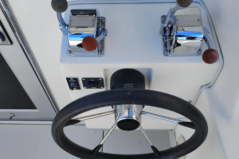 Slide: The Image of Steering wheel and controls of a 1997 SeaSport Explorer 2400 boat cockpit. - 7