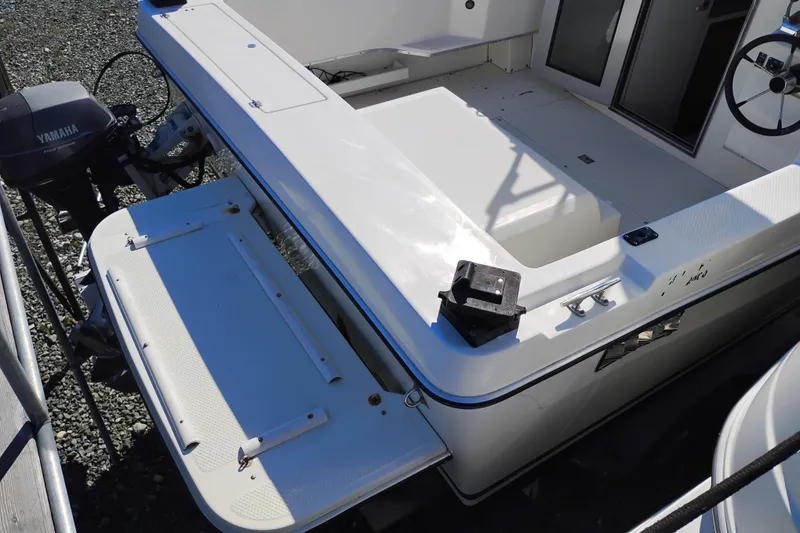 Slide: The Image of 1997 SeaSport Explorer 2400 boat deck with Yamaha outboard motor, featuring open storage and seating area. - 8