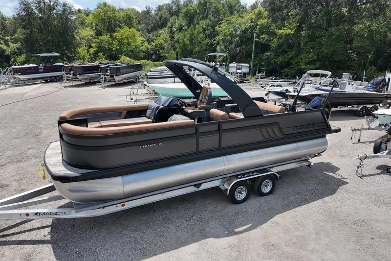 Slide: The Image of 2026 Viaggio Diamante 24 S pontoon boat on trailer in a marina setting. - 2