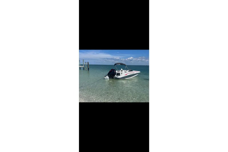 Slide: The Image of Tahoe 1950 boat in clear water, 2023 model, anchored near a dock. - 10