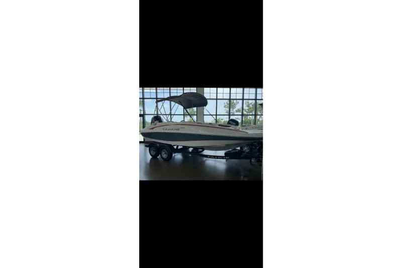 Slide: The Image of 2023 Tahoe 1950 boat on trailer in showroom with canopy. - 11
