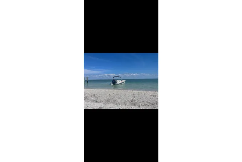 Slide: The Image of Boat on sandy beach with clear blue sky and ocean, Tahoe 1950 model, 2023. - 12